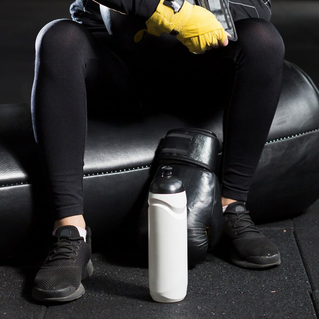 boxer-met-gele-handschoenen-en-water-zit-in-de-sportschool